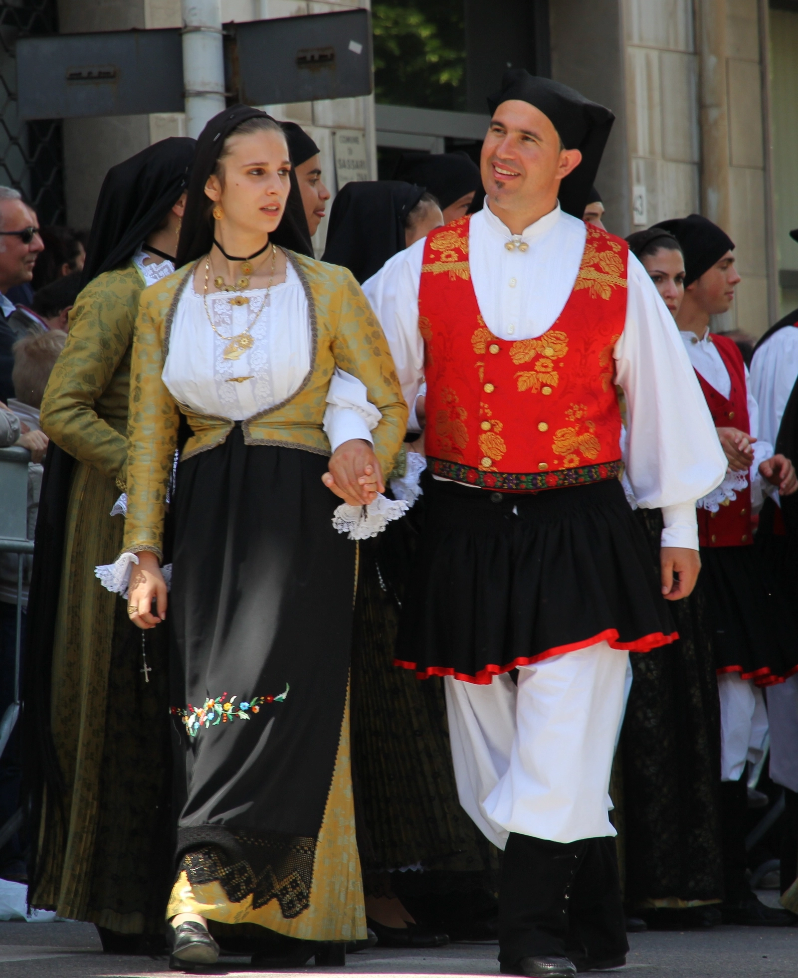 Traditional dress and costume of Barisardo - couple in festive dress: gold damask silk gippone with black lace antaleni and red corpettu