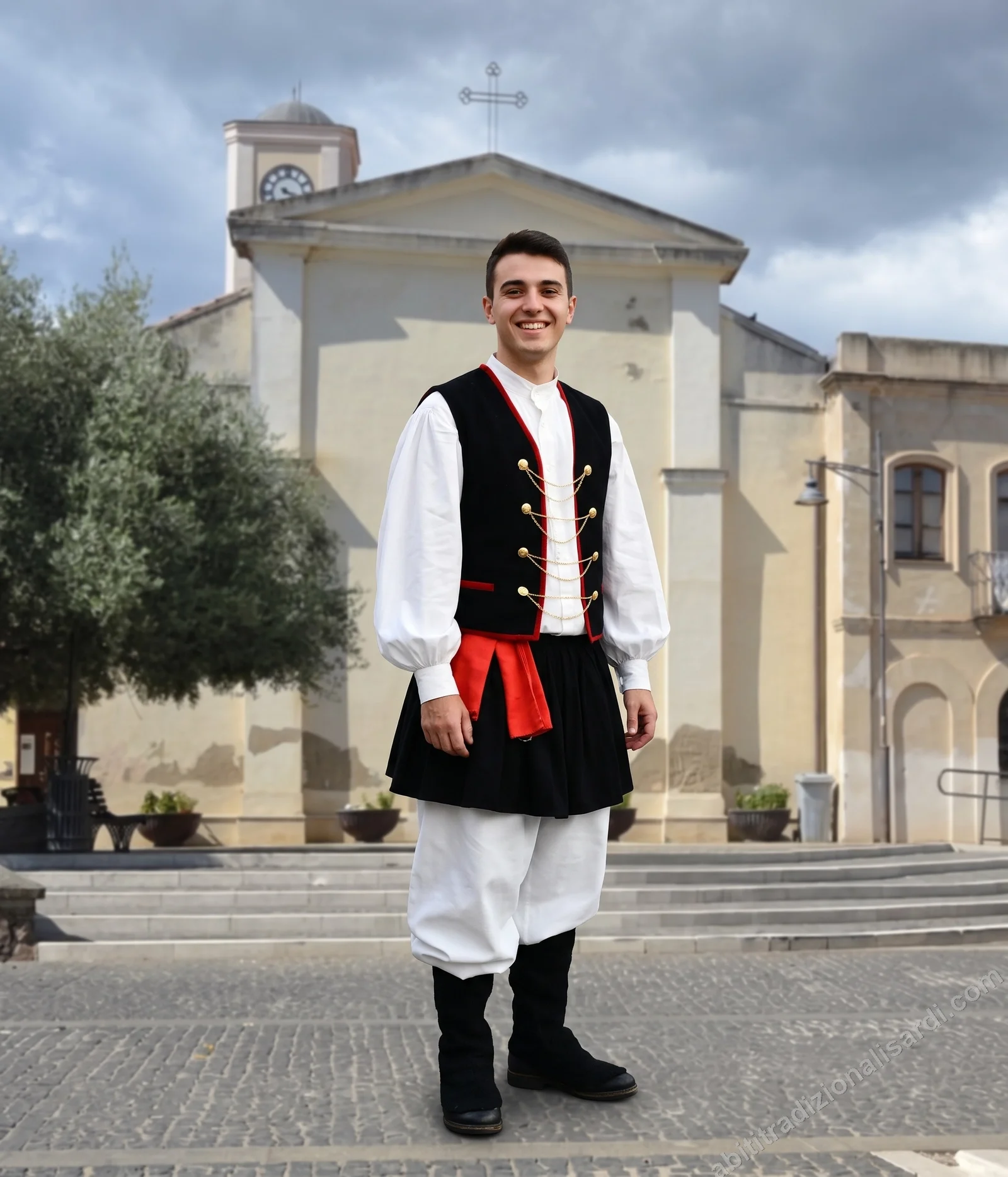 Dettagli del costume e abito di Musei - ragazzo in abito tradizionale maschile festivo davanti alla chiesa